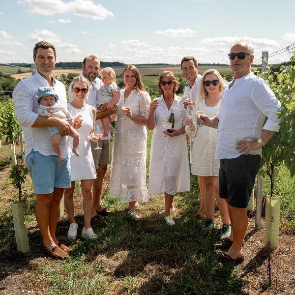 Family posing for a photo in a vineyard