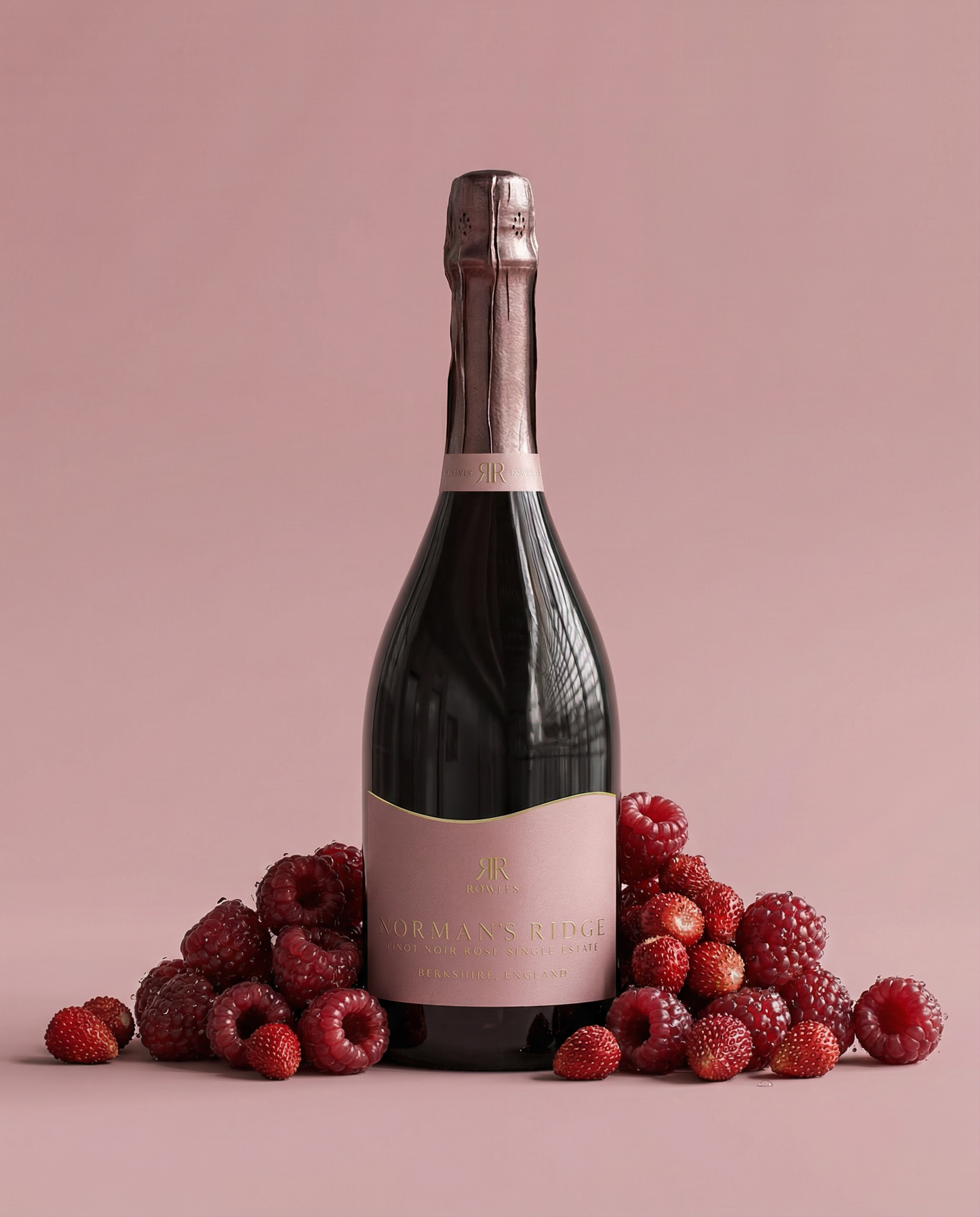 Bottle of Norman's Ridge with raspberries on a pink background