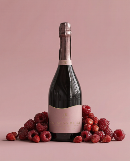 Bottle of Norman's Ridge with raspberries on a pink background