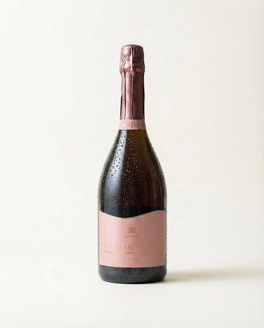 Bottle of sparkling wine with a pink label on a light background