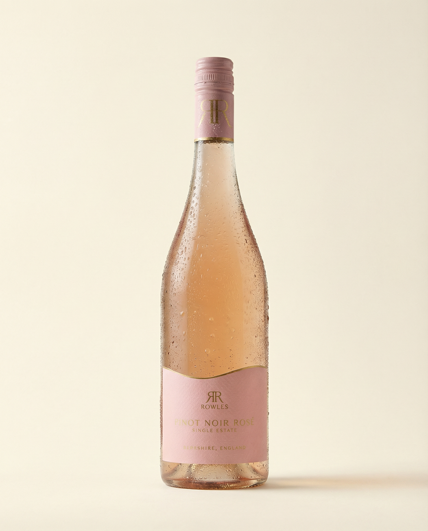 Bottle of Rosé wine with a pink label on a beige background