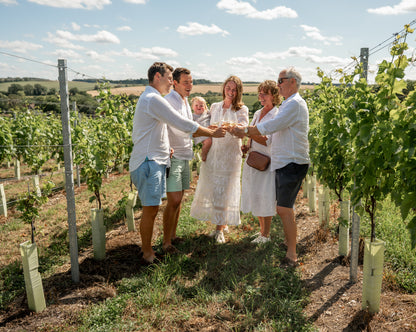 Carlise family standing in a vineyard, enjoying a wine tasting