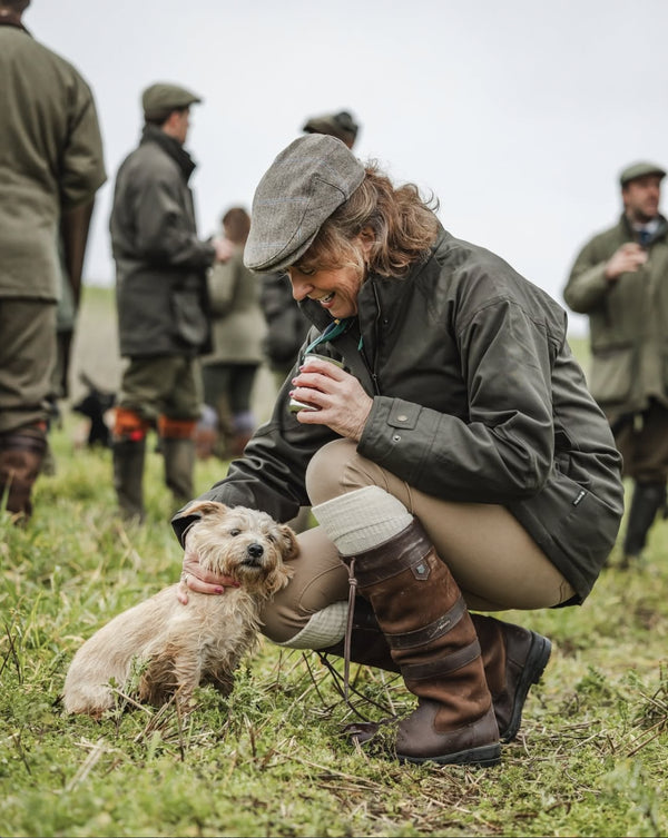 Sandra with a dog, surrounded by people in similar attire.